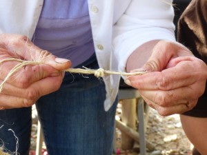 Marion ties a loop in the end of some twine to create a hanger for the Kokedama